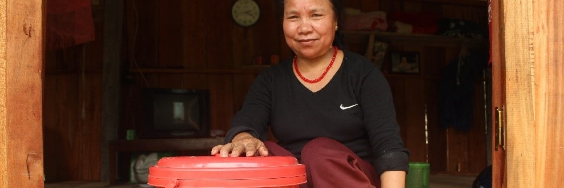 Une femme assise avec un seau de produits d'hygiène